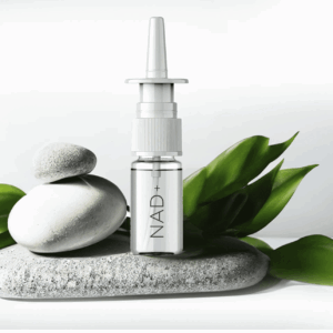 NAD+ nasal spray bottle placed on smooth stones with green leaves, promoting wellness and vitality in the context of health products for sale at Combat Medic Wellness.